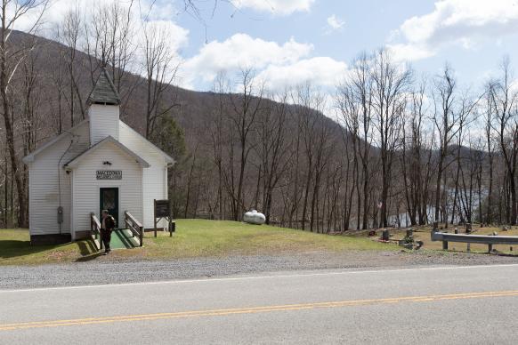 The Rev. Bradley Barton exits Macedonia United Methodist Church near Parsons, W.Va. Barton, who is a correctional officer at the Tygart Valley Regional Jail in Belington, often leaves his job at the jail just in time for worship and preaches while still in his jail uniform. Photo by Mike DuBose, United Methodist Communications.