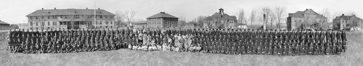 large group assembled in front of school buildings