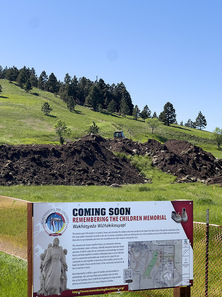 Construction site with project sign in foreground